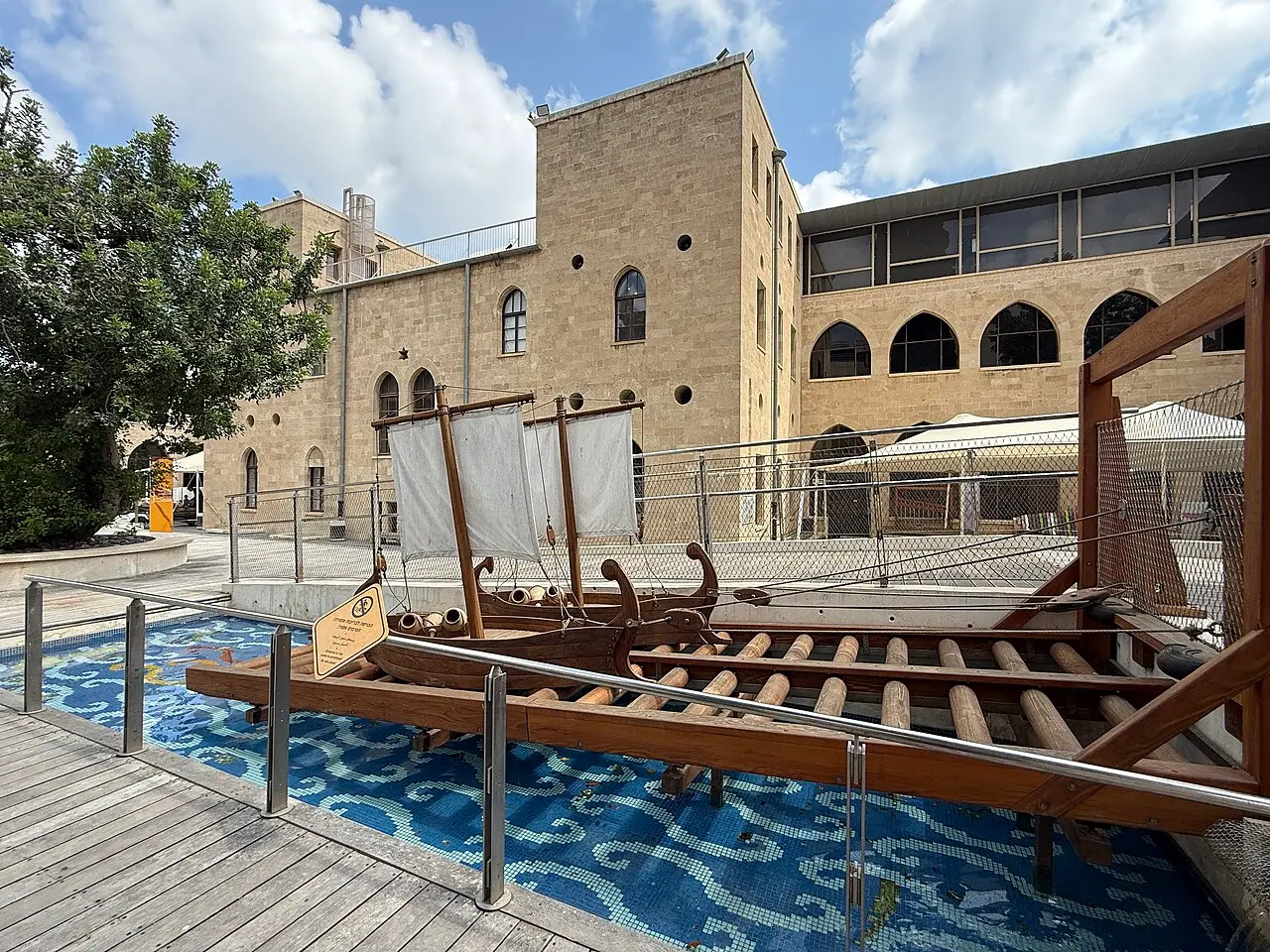 A courtyard at MadaTech with model boats set on a blue mosaic pool