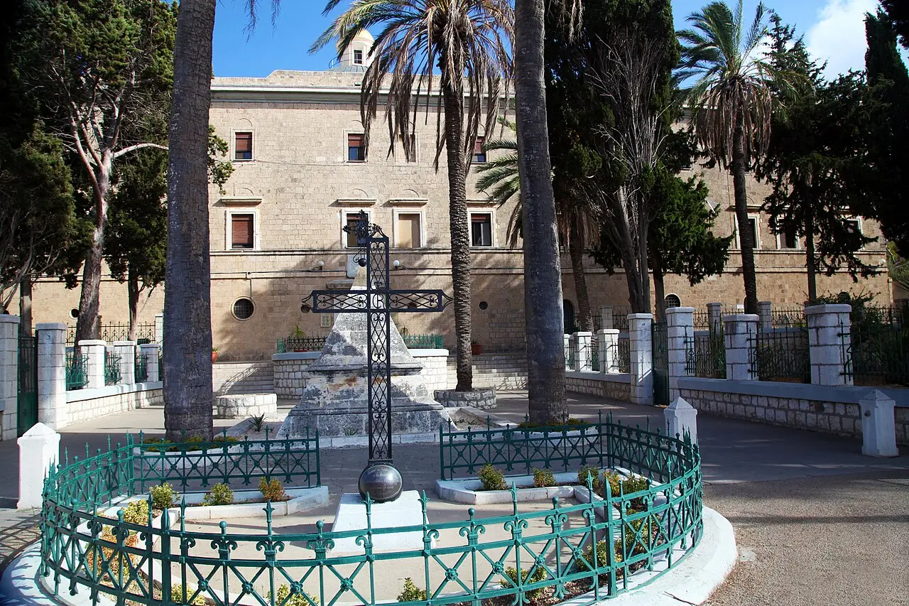 The fenced memorial in front of the Stella Maris monastery, topped with an iron cross