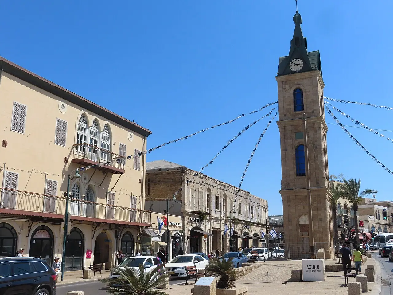 The Jaffa Clock Tower standing in its square, strings of flags running from it