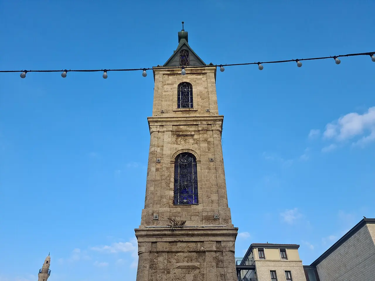The upper storeys of the Jaffa Clock Tower, a coloured-glass window below the clock face