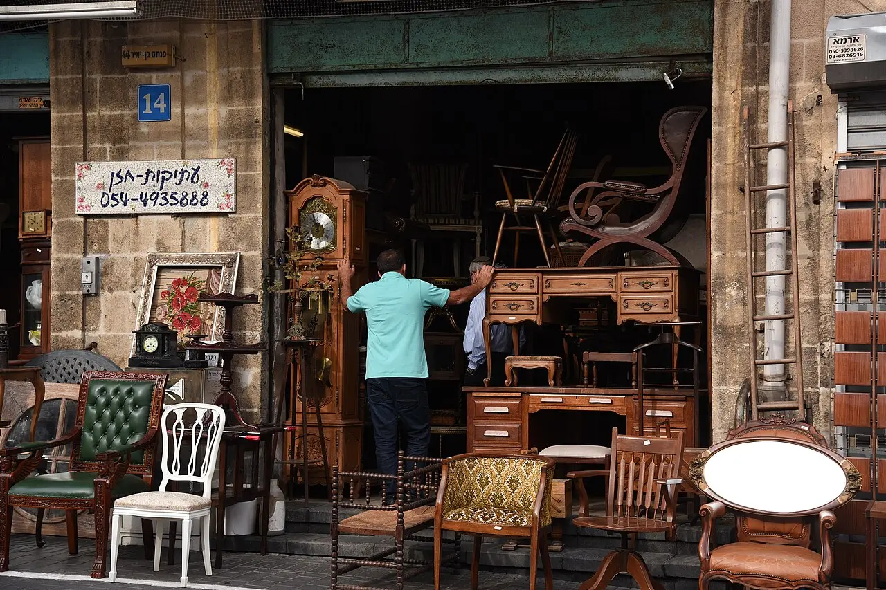 Antique furniture and clocks spilling out of a shop in the Jaffa flea market