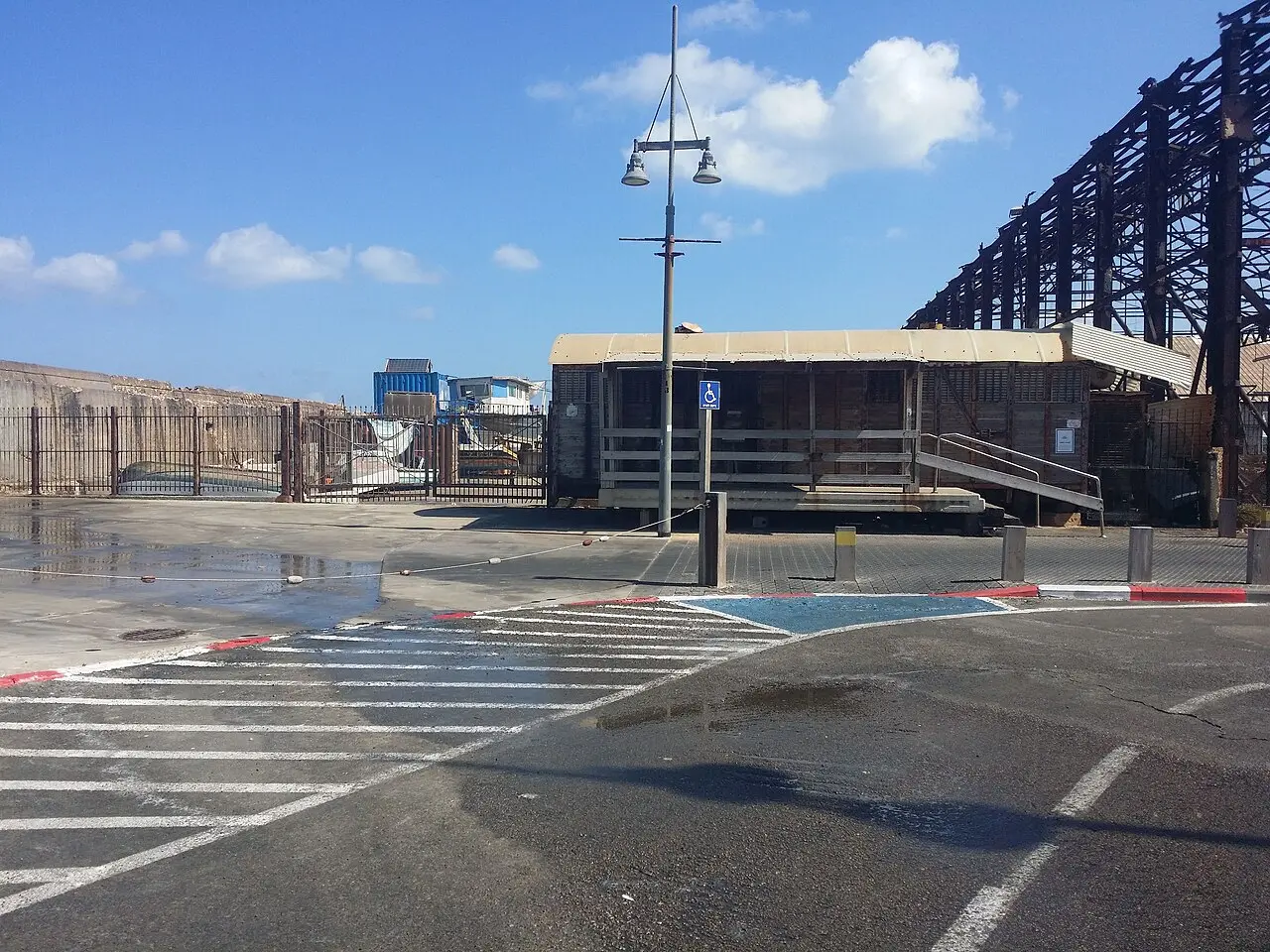 A timber workshop in Jaffa Port, the steel frame of a warehouse behind it