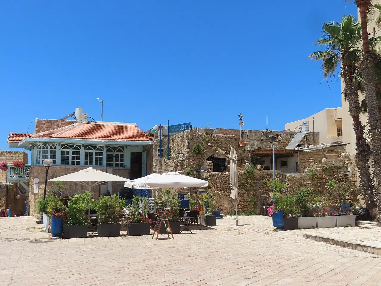 The paved expanse of Kedumim Square, café umbrellas along its edge