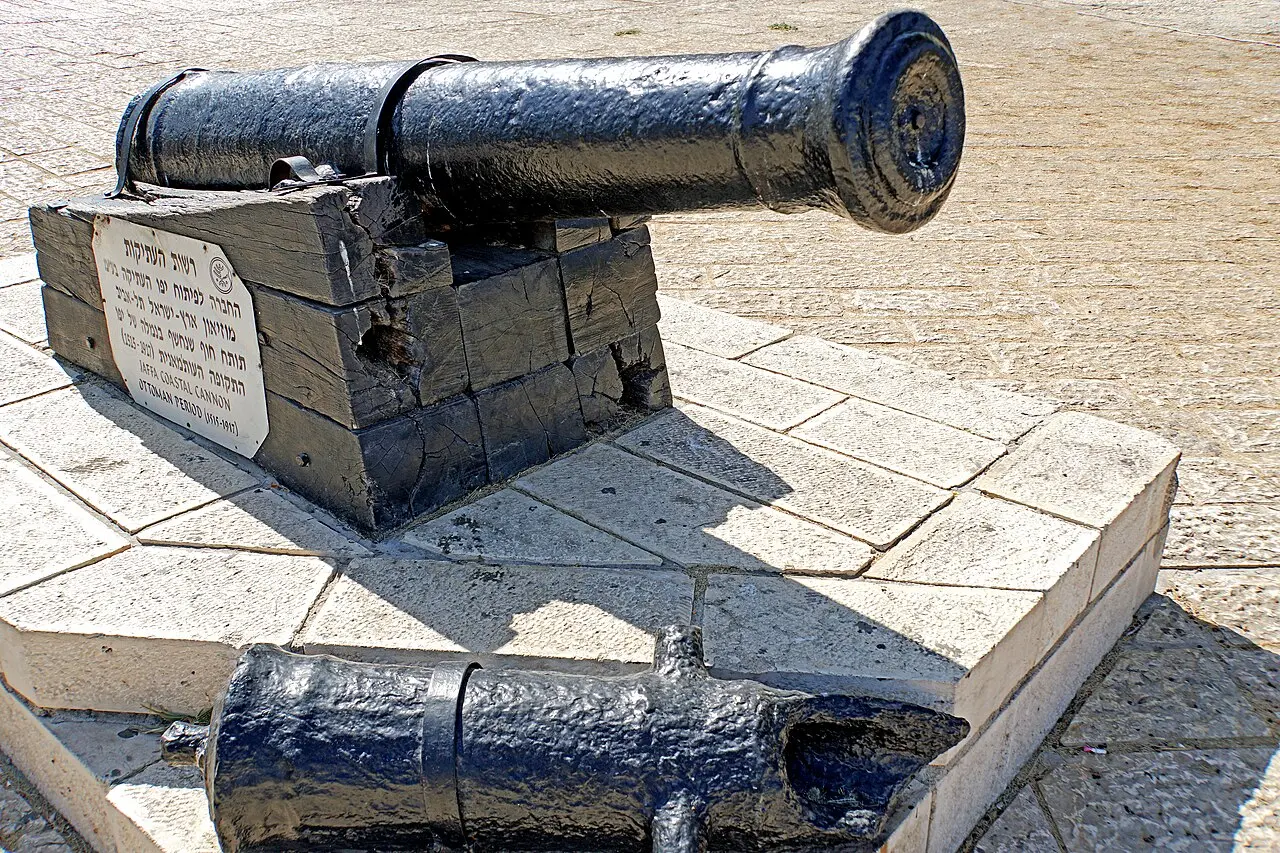 Cast-iron cannons found in Jaffa's harbour, mounted on a stone base near the church