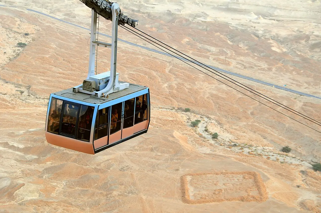 A cable car cabin over the desert floor on its way up Masada