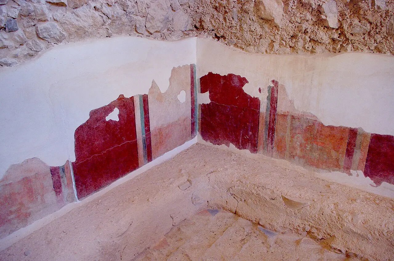 Painted wall plaster in red and black panels inside the bathhouse on Masada
