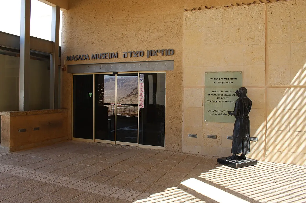 The entrance to the Masada Museum, a bronze figure standing beside the doors