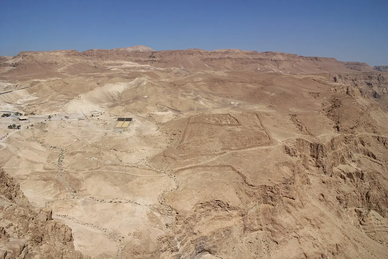 The stone outline of a Roman camp and the siege wall seen from Masada's summit