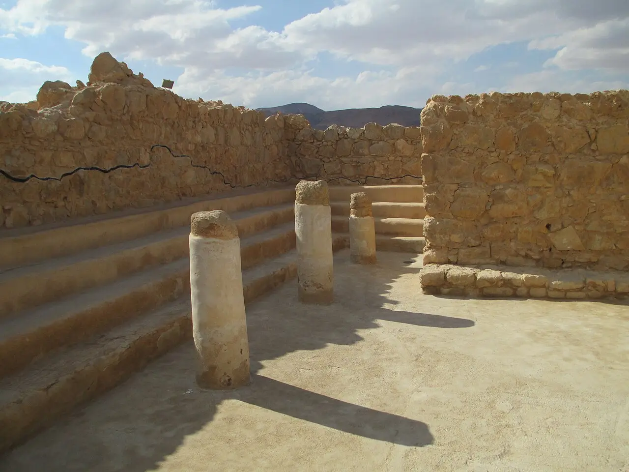 Column drums and stepped benches in the Masada synagogue, the casemate wall behind