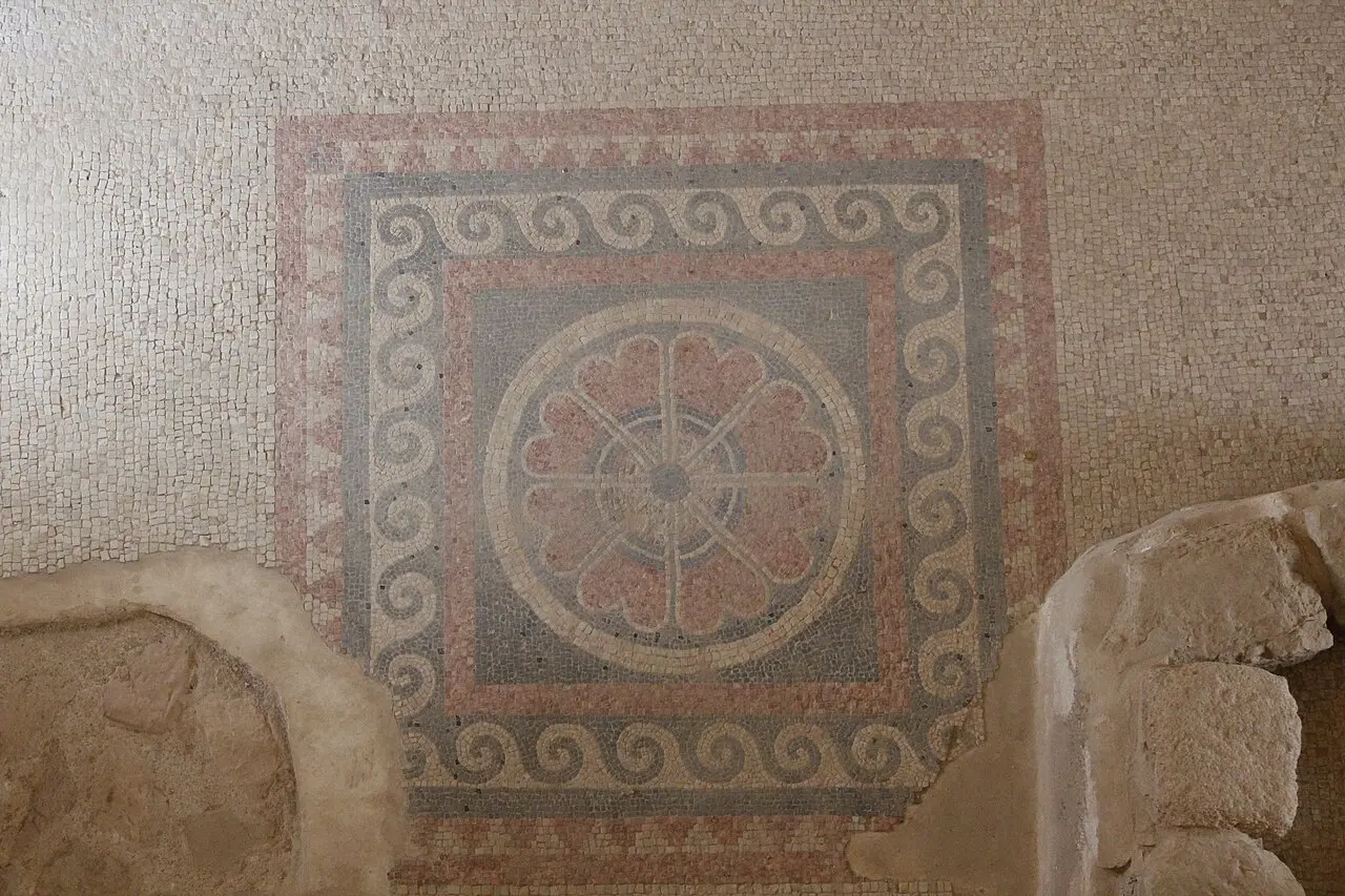 A mosaic floor with a rosette inside bands of geometric pattern in the Western Palace