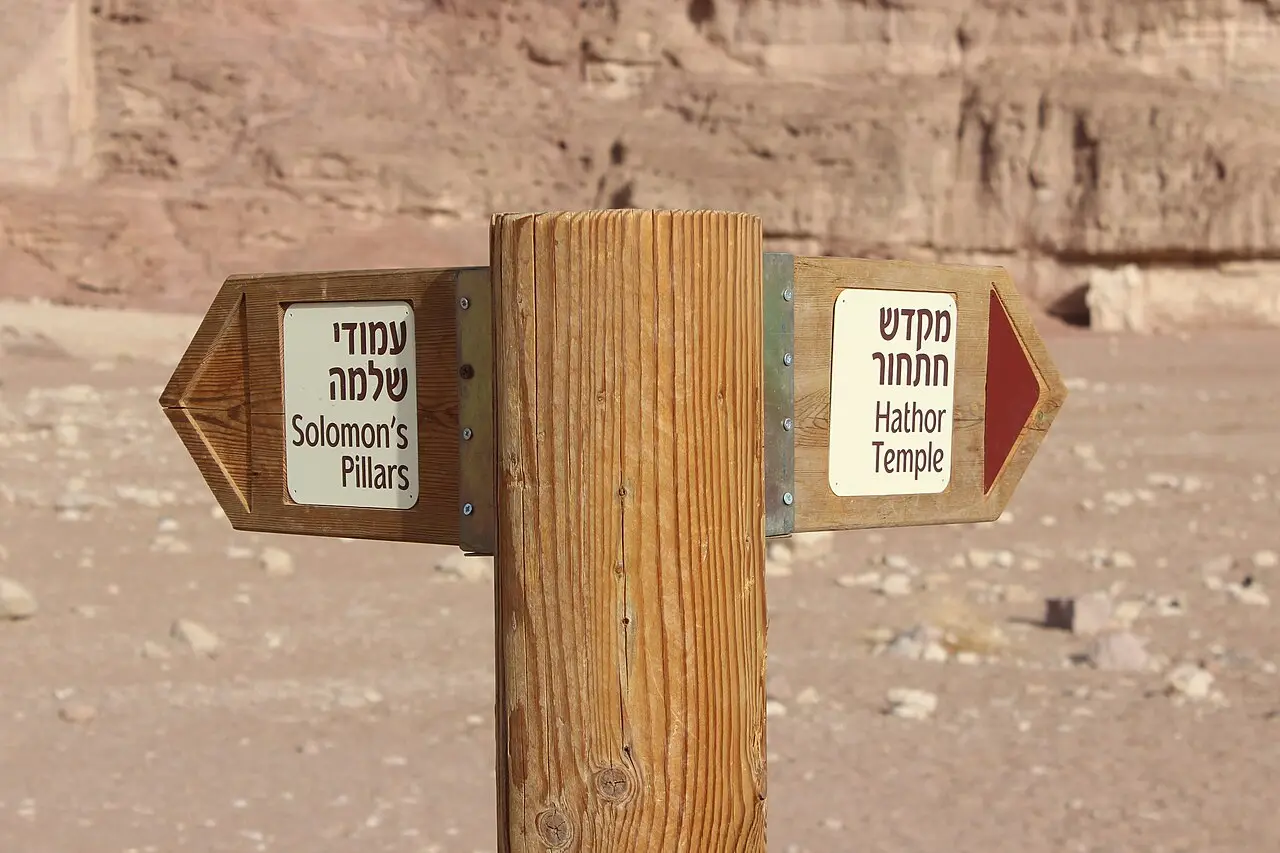 A wooden signpost in Timna Park pointing to Solomon's Pillars and the Hathor Temple