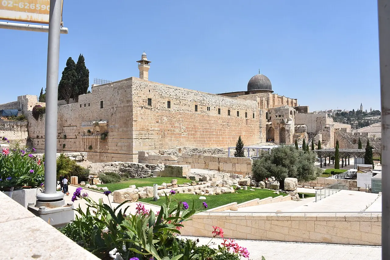 The southern wall of the Temple Mount above the excavations, the grey dome of al-Aqsa behind it