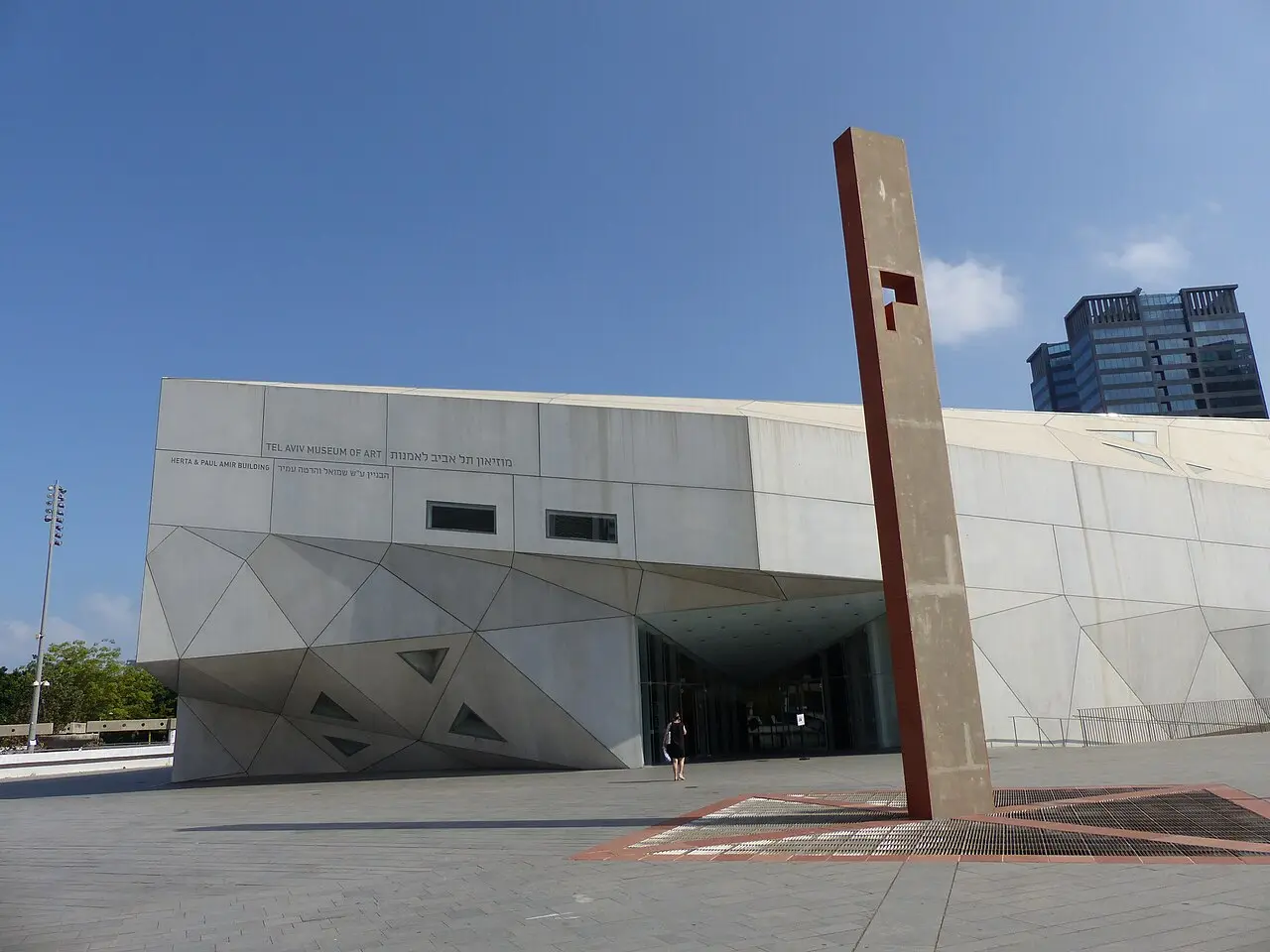 The folded concrete planes of the Herta and Paul Amir Building, a tall steel sculpture in front