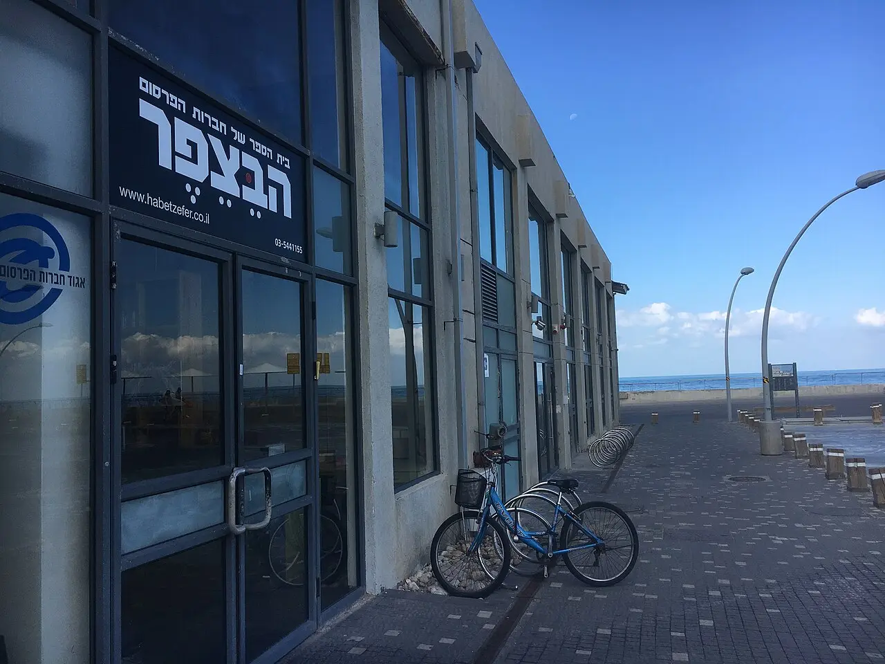 The glass front of Hangar 1 on the boardwalk at Tel Aviv Port, a bicycle parked outside